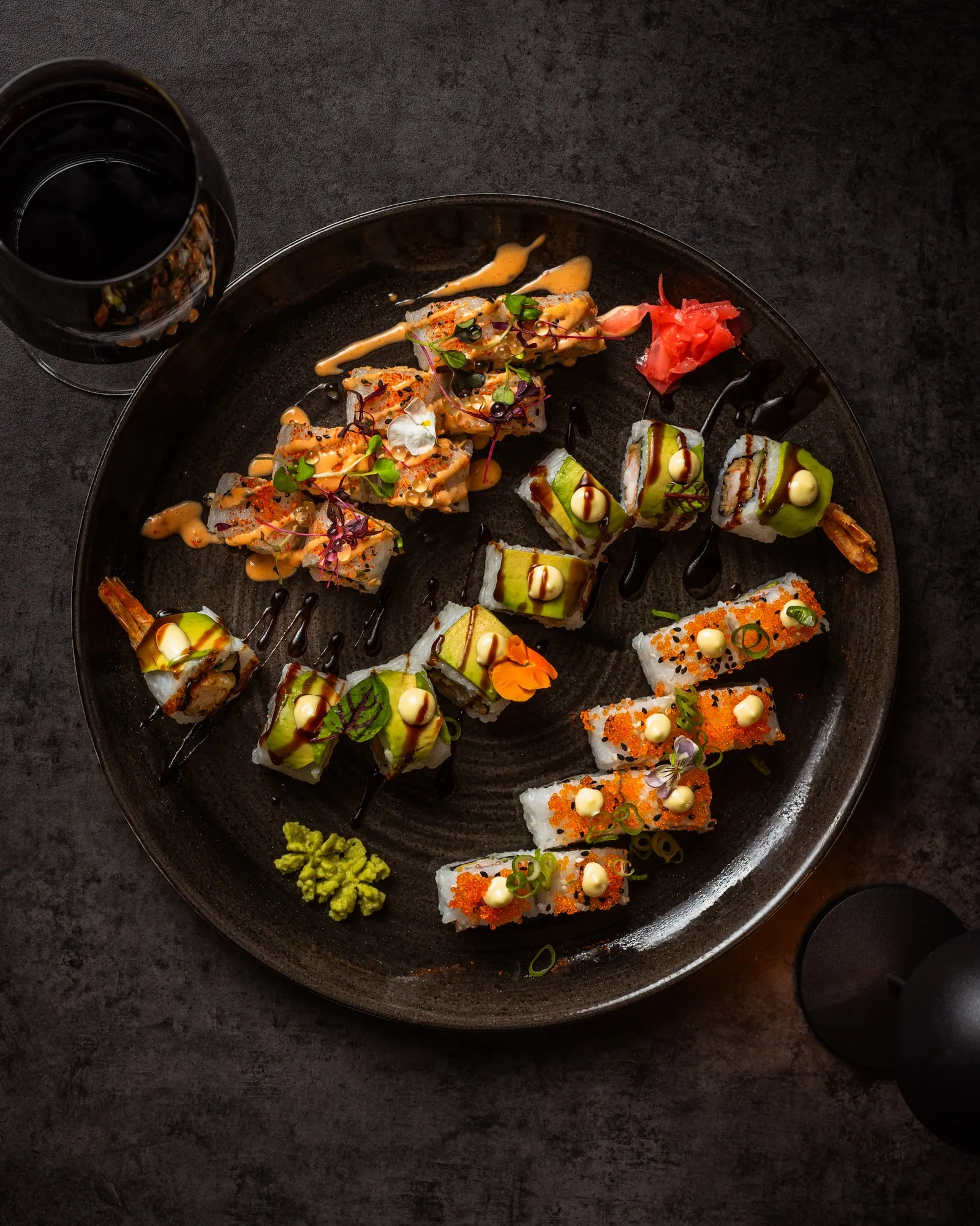 A round platter filled with assorted sushi rolls.